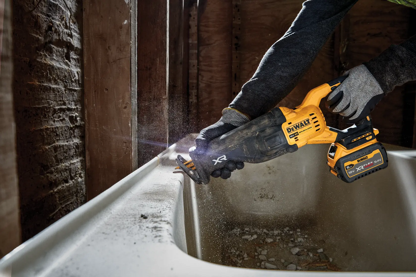 Persona usa una sierra recíproca DEWALT inalámbrica para cortar junto a una bañera.