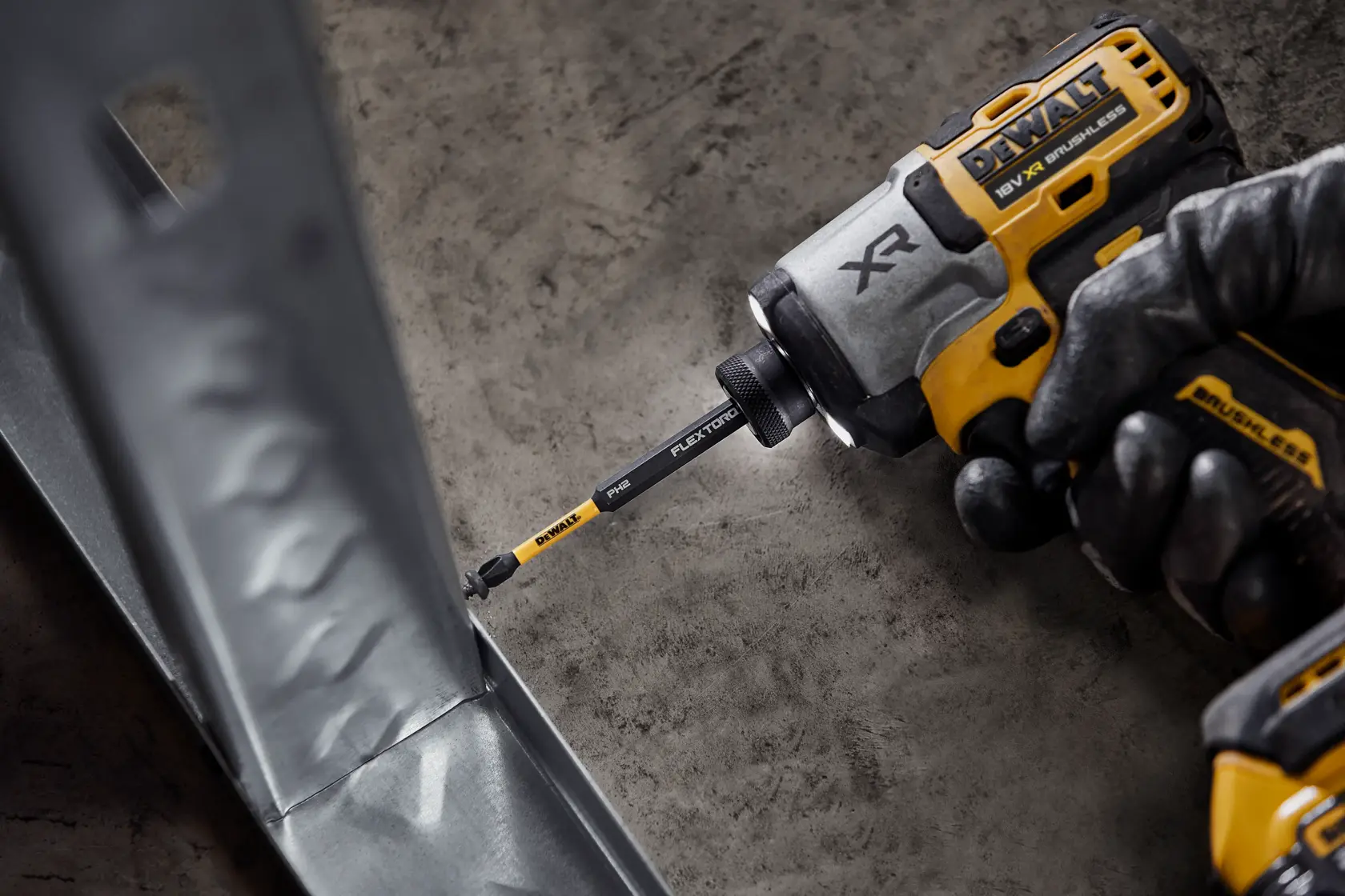 DEWALT atornillador de impacto con punta FlexTorq atornilla en metal, trabajador con guantes.